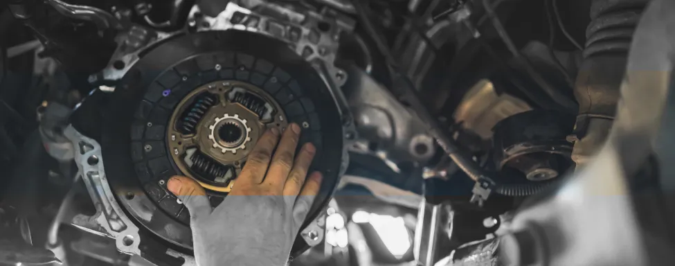 Transmission Repair In Sterling, VA At Honest Tom Care. A close-up, low-angle shot of a car's transmission from underneath the vehicle.