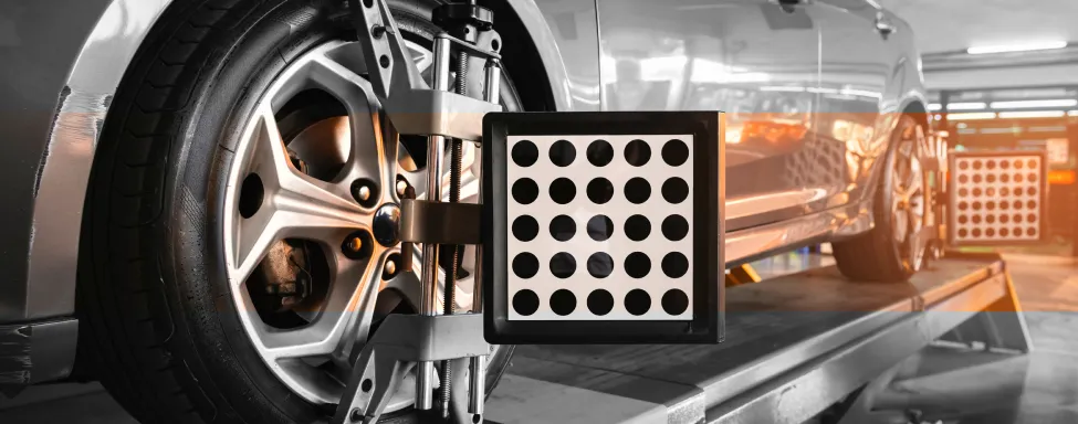 Wheel Alignment In Sterling, VA At Honest Tom Care. A car wheel with a wheel alignment sensor mounted on the rim, used for checking tire alignment.